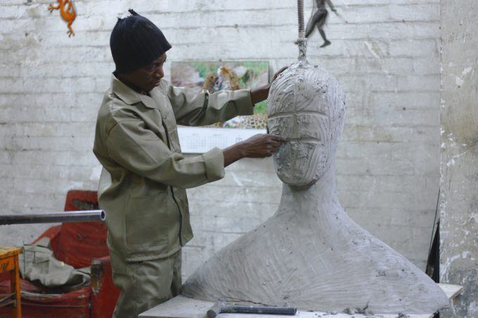 man sculpting an art piece