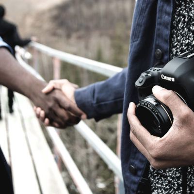 Photographer shaking hands with another man.