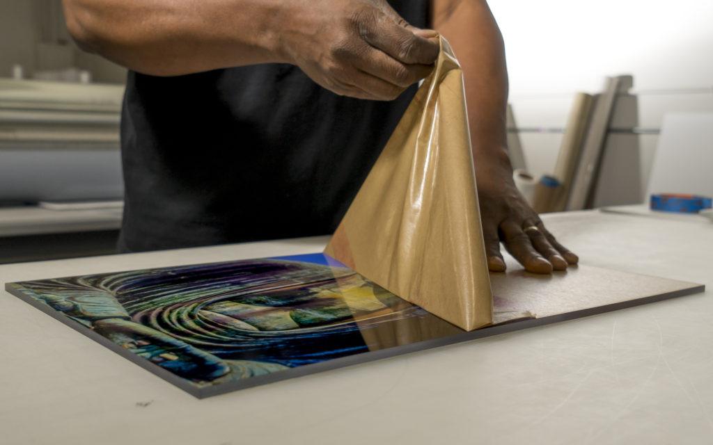 A photo of an acrylic photo print being finished at a fine art print studio.