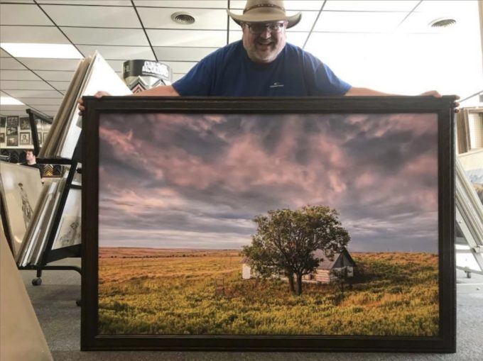 photographer jim holding large framed photo print