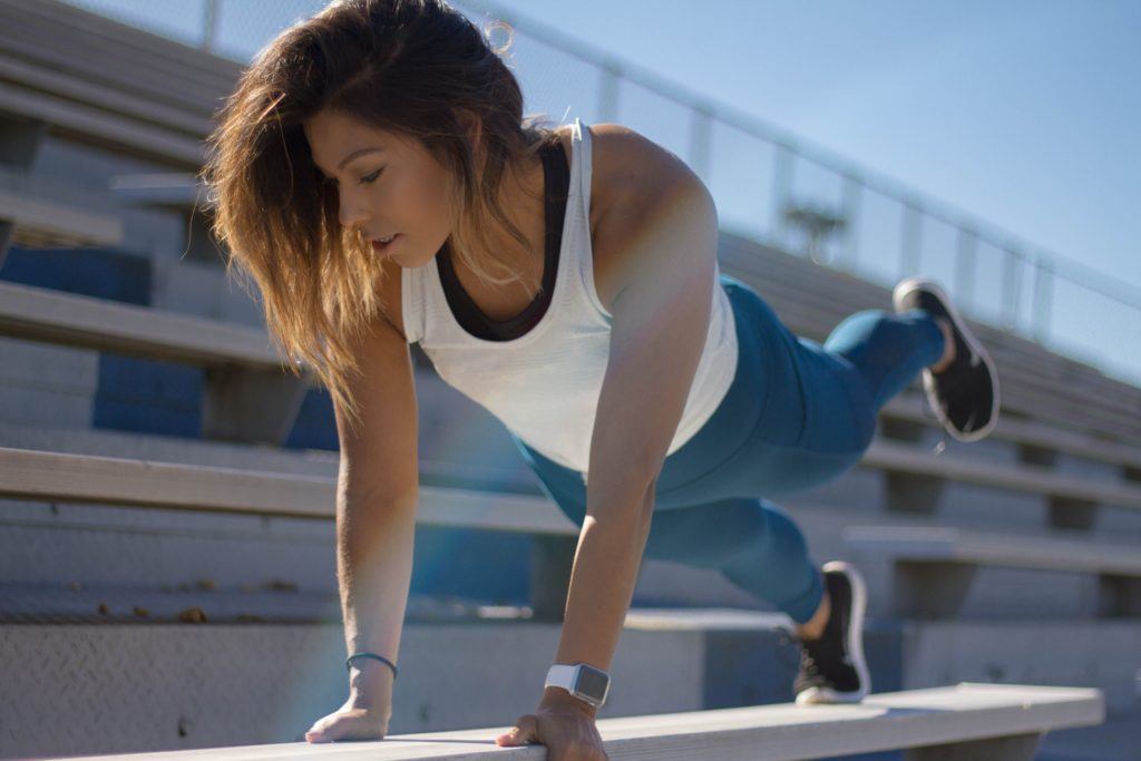 Girl working out on a stadium bench